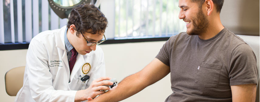 Doctor examining skin on man's arm