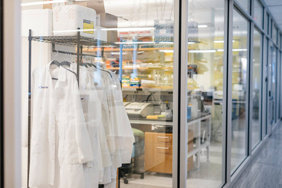 white uc san diego lab coats hanging in a lab